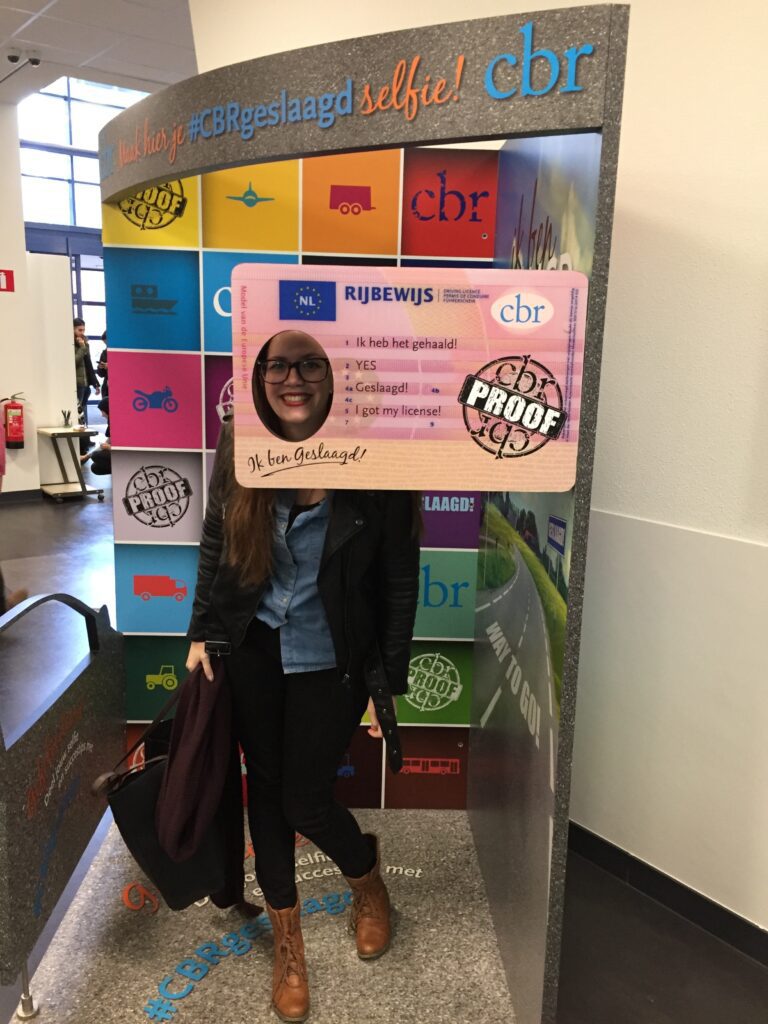 Nieuwe bestuurder met foto in rijbewijskaart straalt na geslaagd examen.